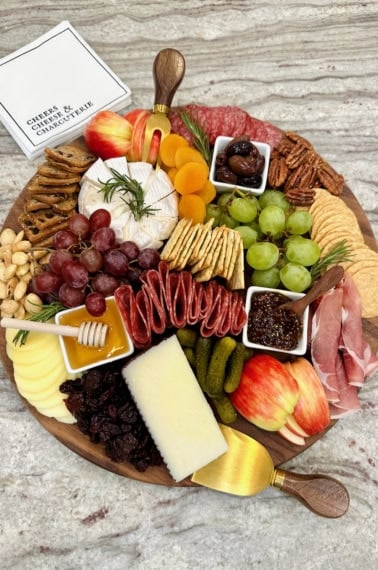 A charcuterie board on a gray marble counter.