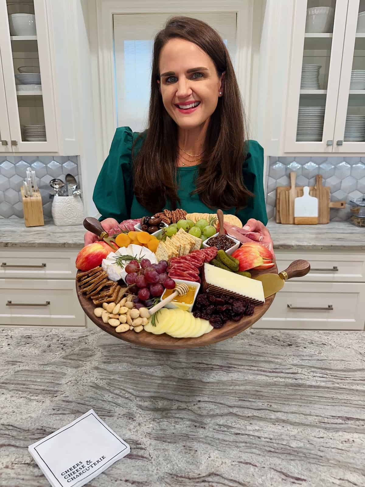 Maegan Brown presenting a round charcuterie board.