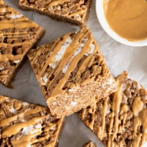 A pile of chocolate peanut butter Rice Krispies treats on a white and gray marble counter.