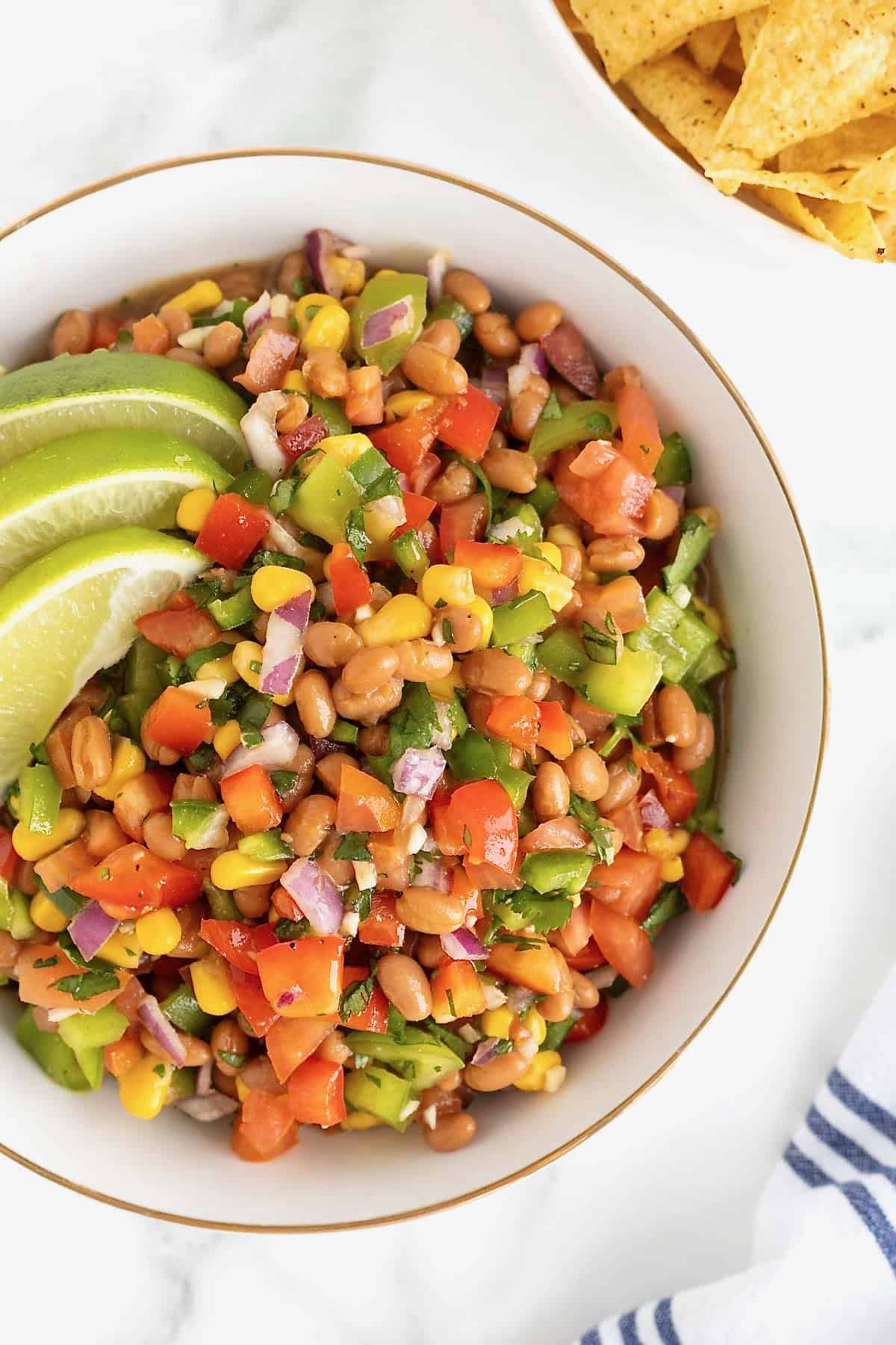 A large gold rimmed white bowl of cowboy caviar.