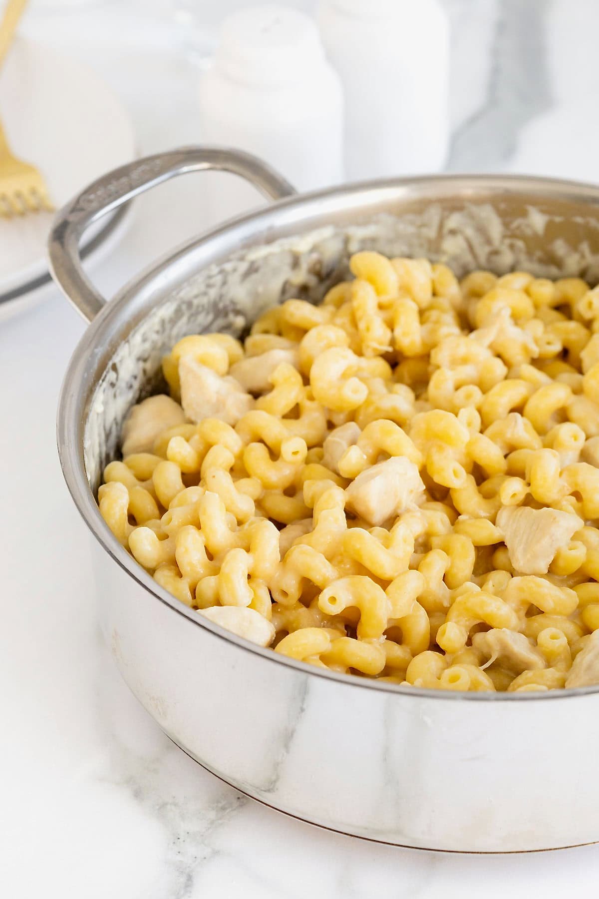 A stainless steel pot of chicken Alfredo with cavatappi pasta.