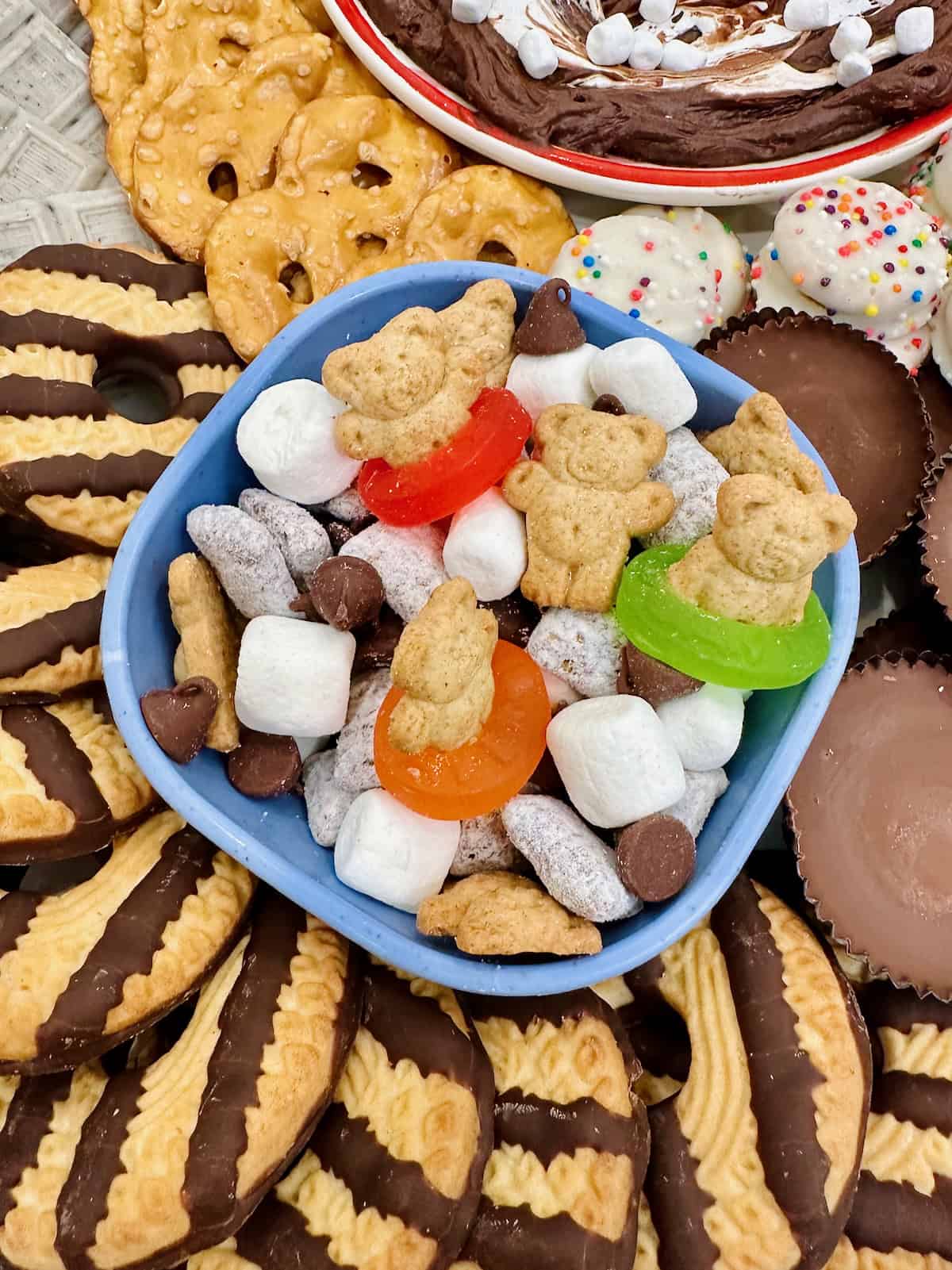 S'mores snack mix in a light blue bowl on a s'mores summer snack board.