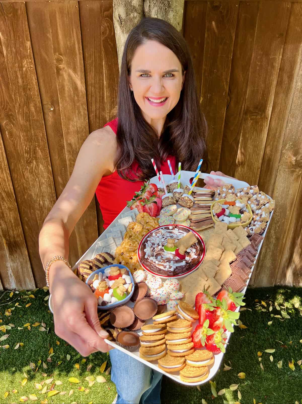 Maegan brown wearing a red tank top holding the kid-friendly s'mores board.