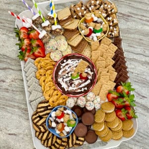 A white plastic tray filled with s'mores treats on a dark grey marble counter.