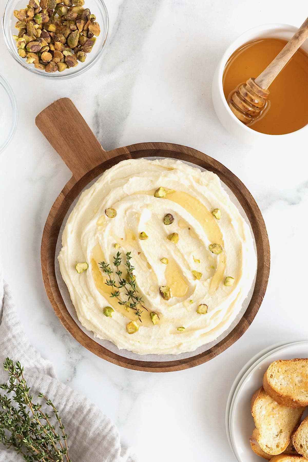 Chopped pistachios sprinkled on a sweet whipped brie dish with honey.