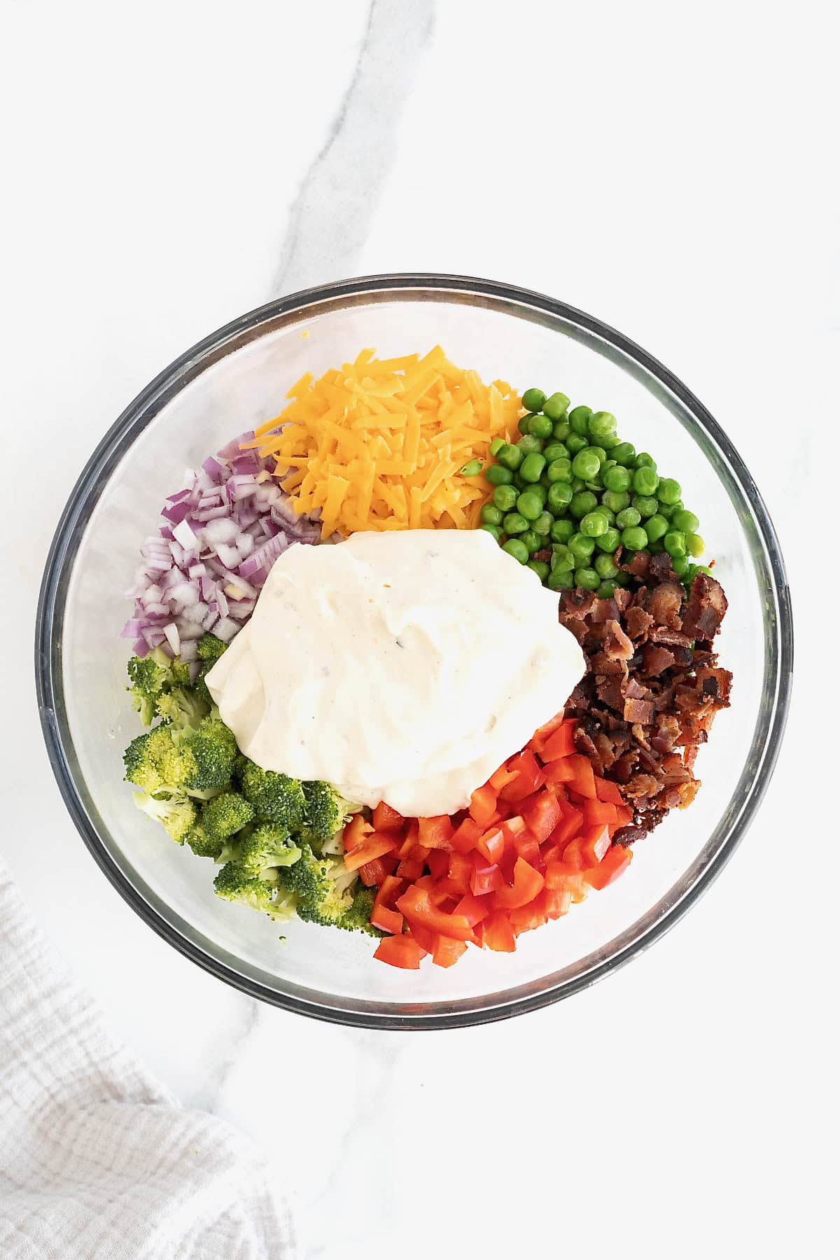 Ranch dressing on top of pasta salad ingredients.