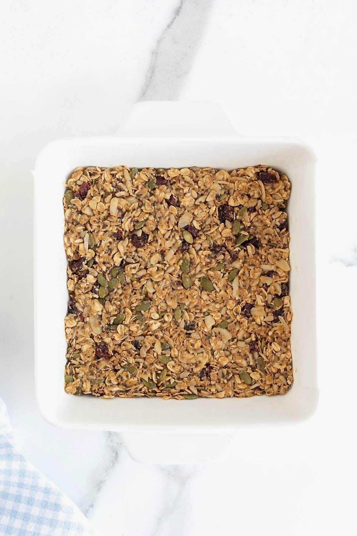 Power bar pressed into a square white baking dish on a white marble counter.