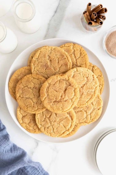 A large white plate of snickerdoodle cookies on a white marble counter.