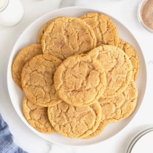 A large white plate of snickerdoodle cookies on a white marble counter.