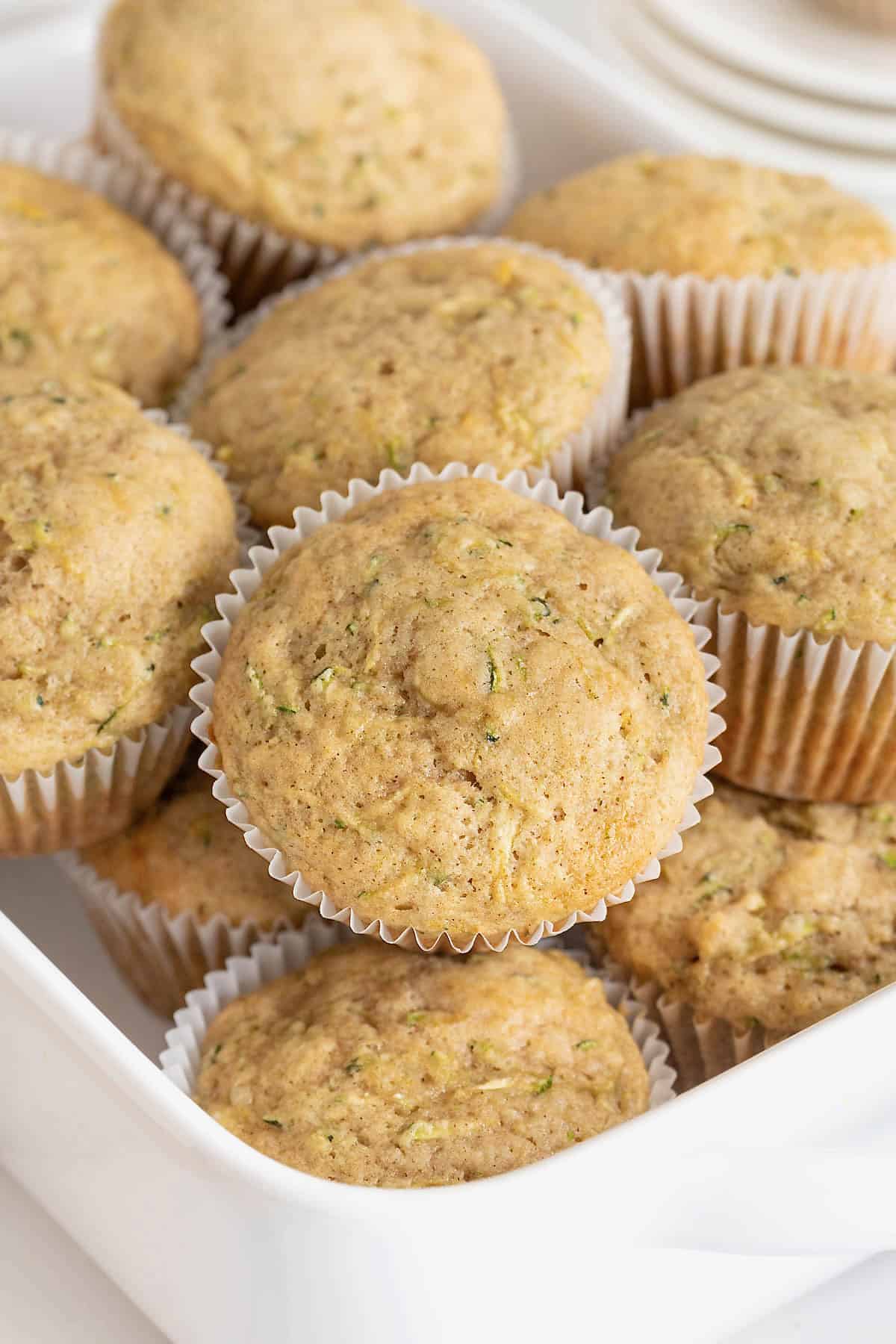 A white rectangular serving bowl of zucchini muffins.