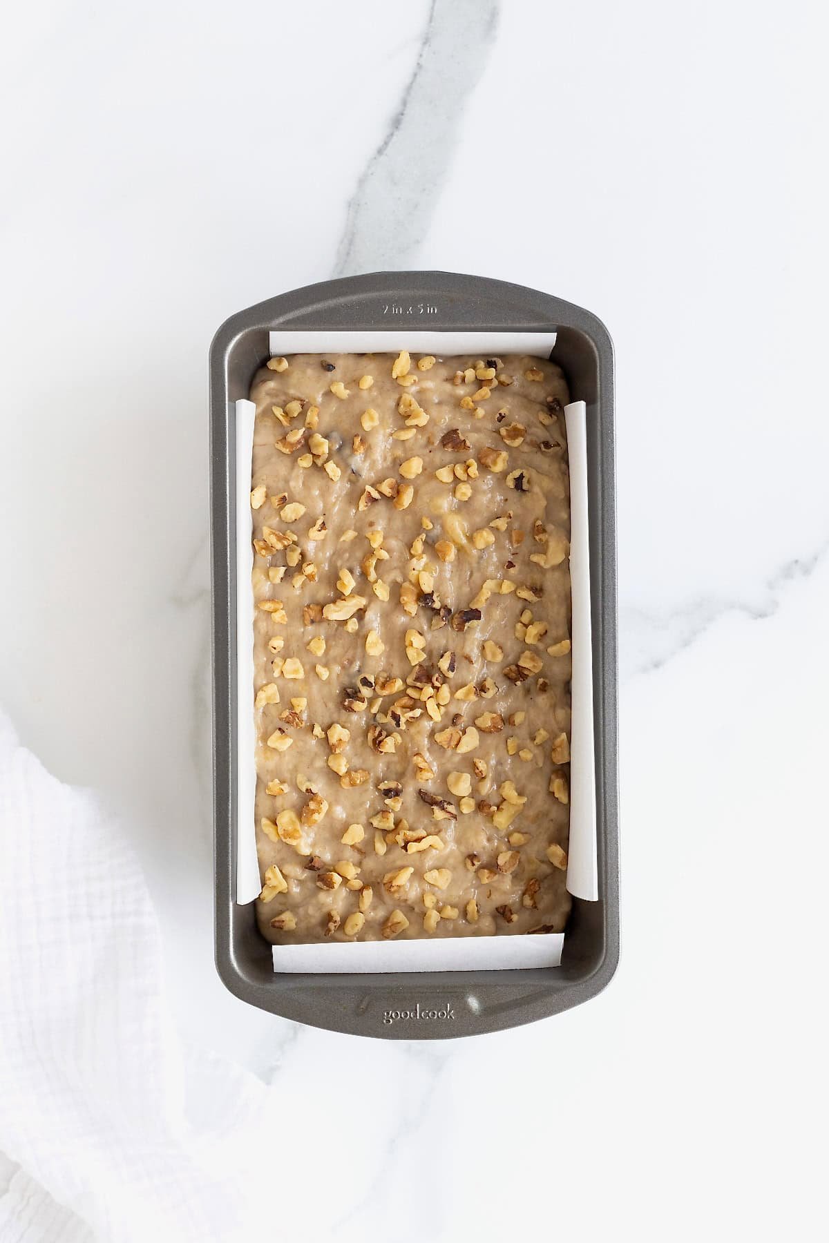 Banana Nut Bread batter in a dark aluminum loaf pan.