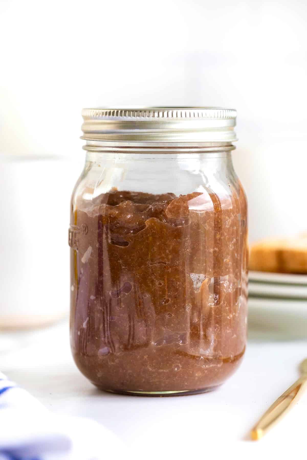 Homemade grape jam in a mason jar with the lid on.