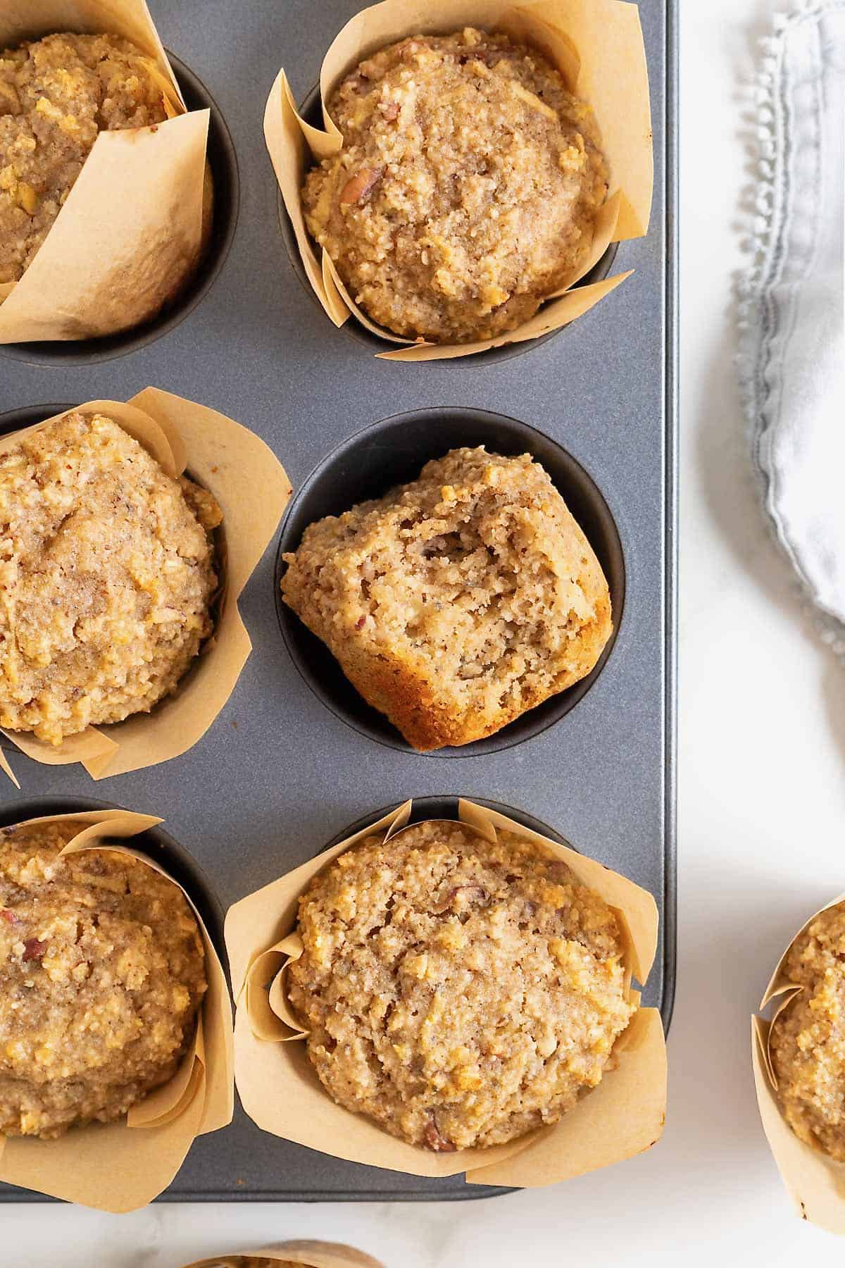 Superfood muffins in brown paper muffin liners in an aluminum muffin pan.