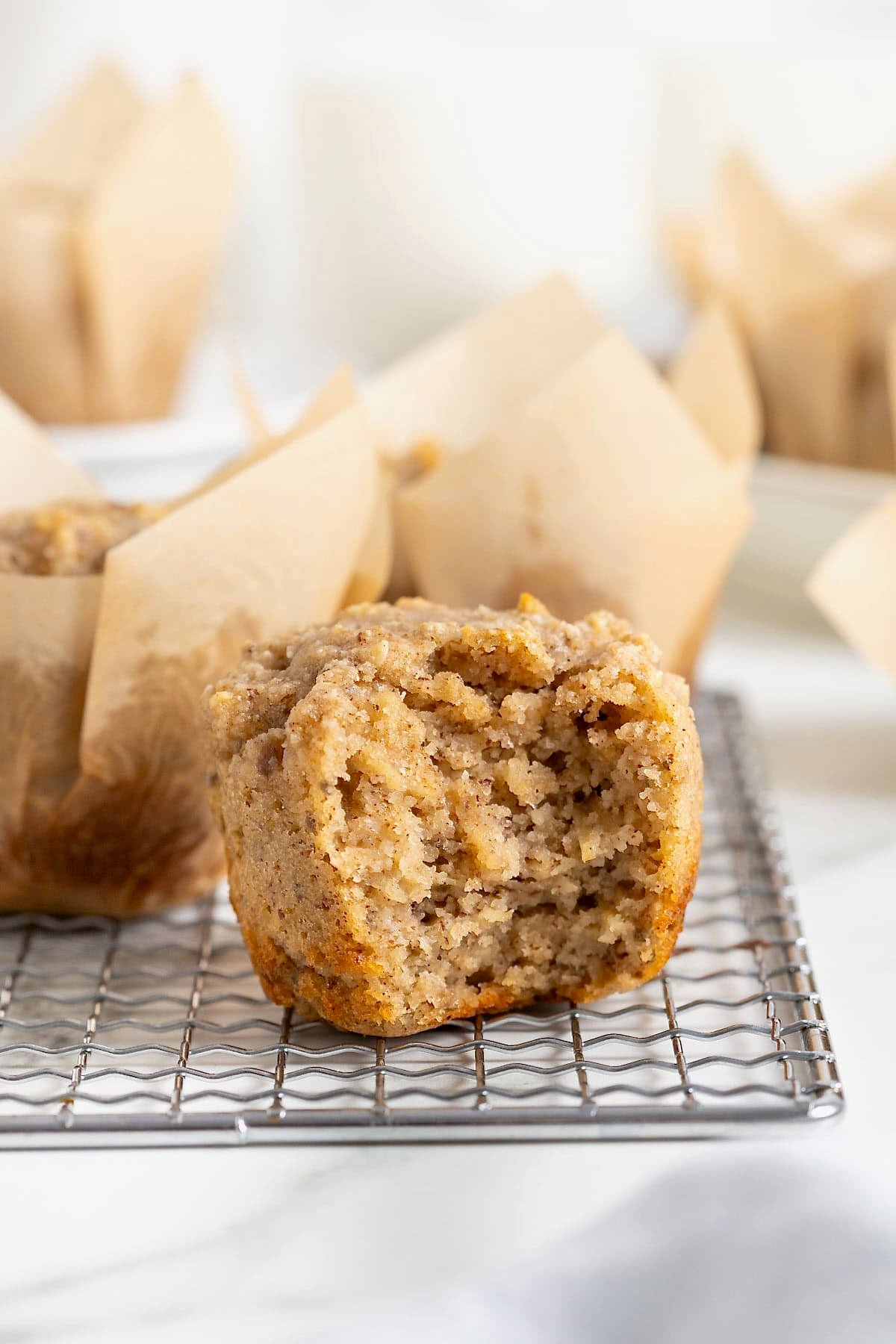 A superfood muffin with a bite out of it on a wire cooling rack.