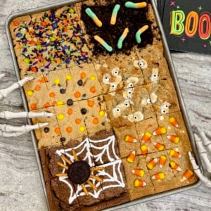 Halloween cookie bars in a sheet pan on a gray and white marble counter.