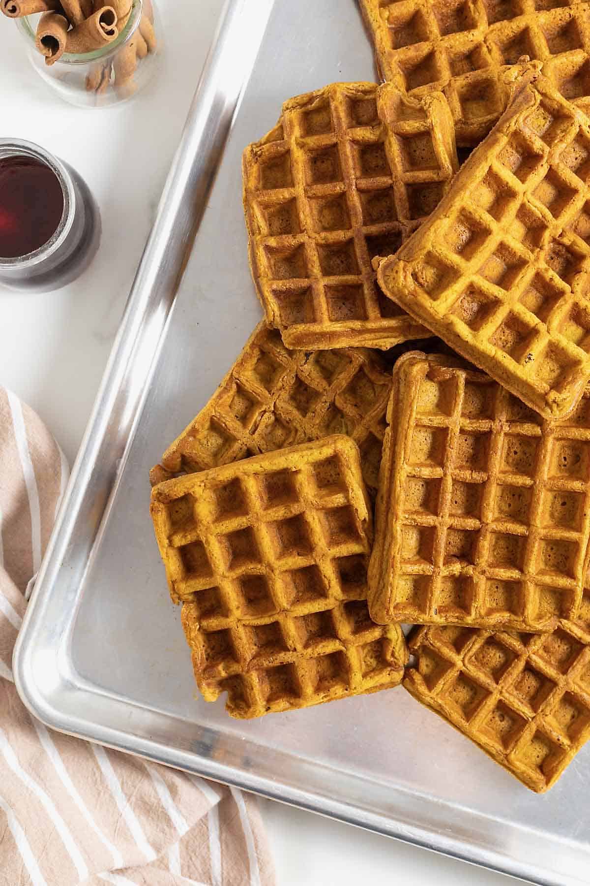 Six waffles on an aluminum baking sheet.