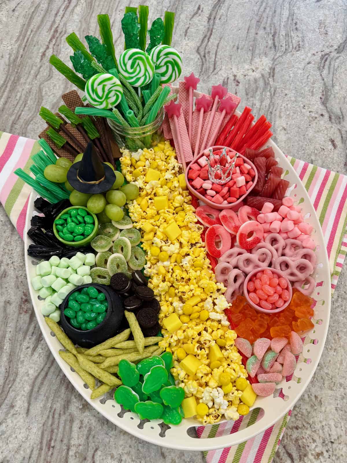 A snack board divided in pink and green snacks to celebrate the movie Wicket on a gray marble counter.