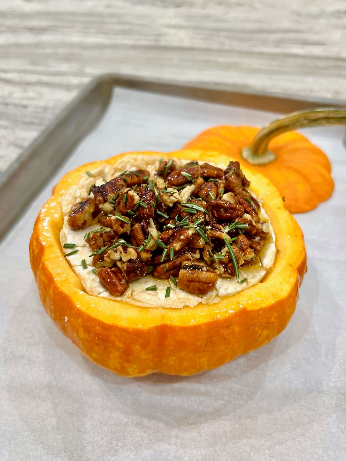Pumpkin baked brie on a parchment lined baking sheet.
