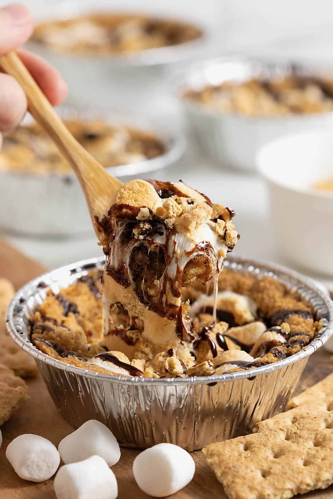 S'mores cookie pie being served on a wooden spoon.
