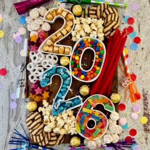 New Year's Eve dessert board featuring number containers filled with candy.