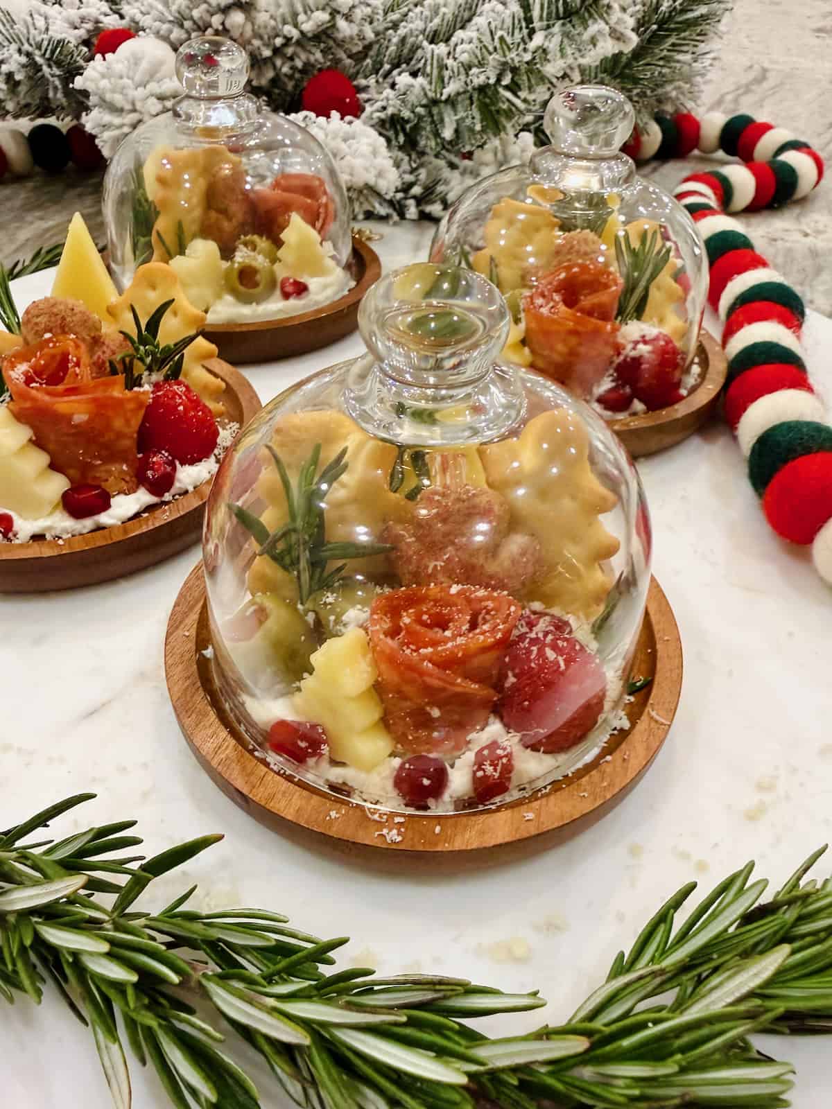 Four small round charcuterie boards feature a salami rose, 