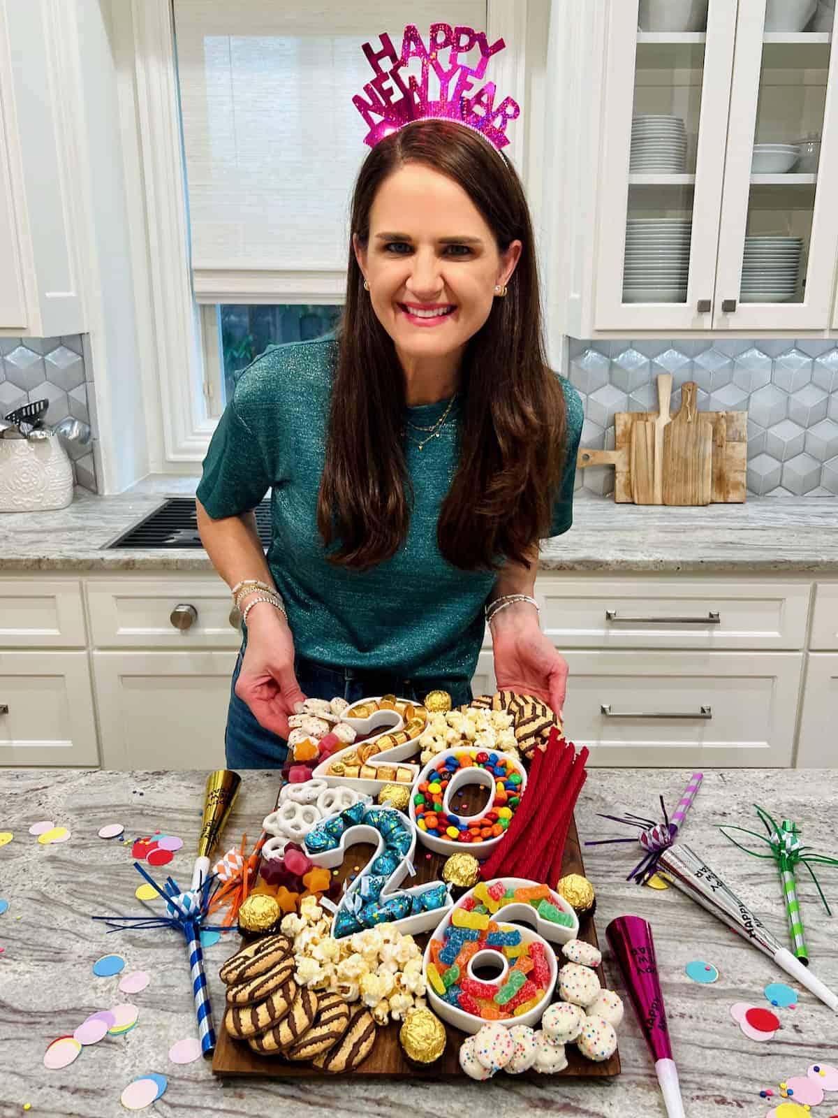 Maegan Brown wearing a New Year's Eve party hat showing off a dessert board.