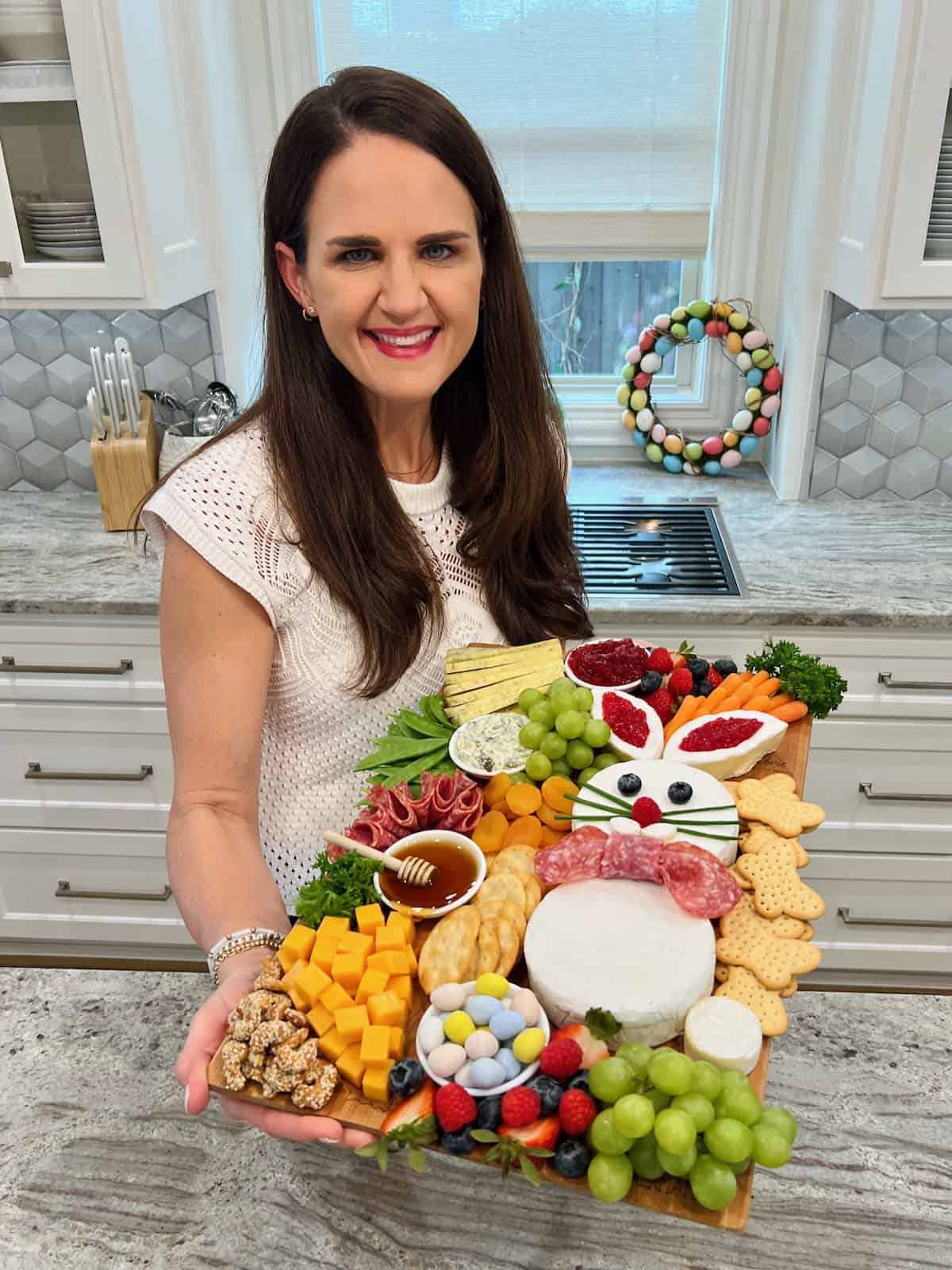 Maegan Brown holding her Easter Bunny Signature Board with a kitchen in the background.