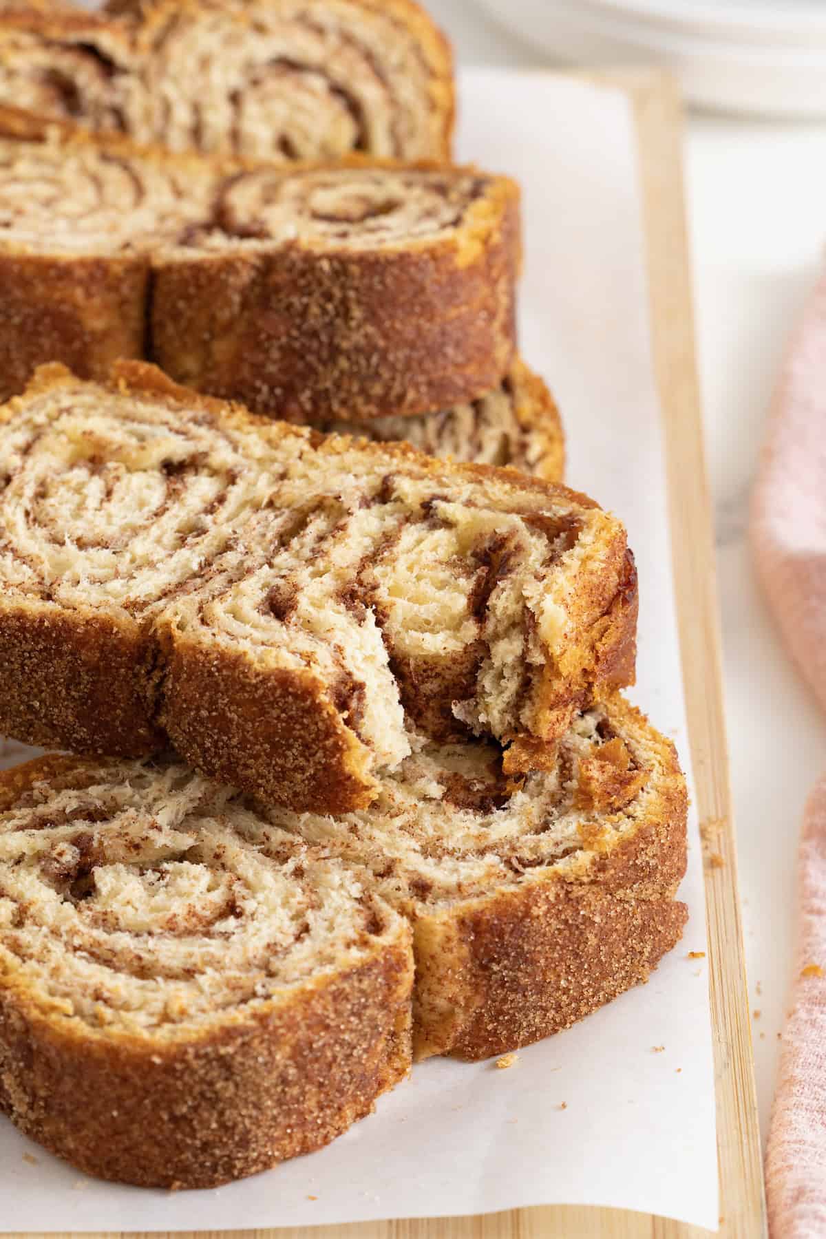 A bite taken out of a slice of cinnamon sugar crescent loaf.