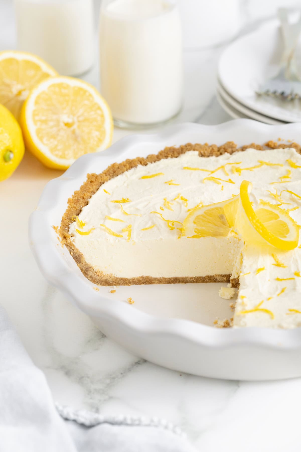 A frozen lemonade pie in a fluted white glass pie plate.