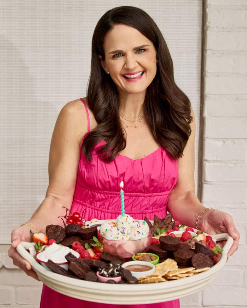 Maegan Brown wearing a pink sundress holding a brownie sundae board.