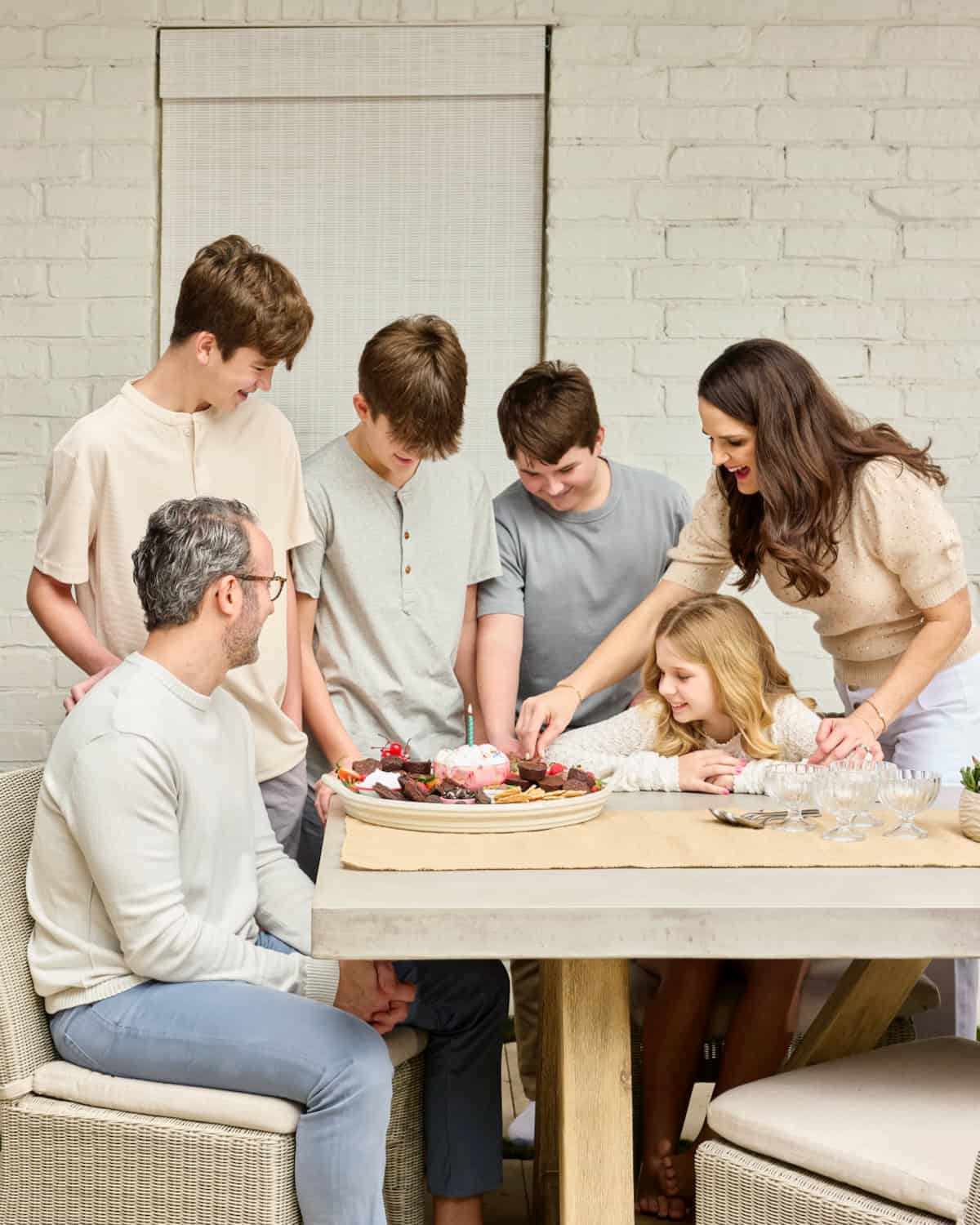 The Brown family eating from a brownie ice cream sundae dessert board.