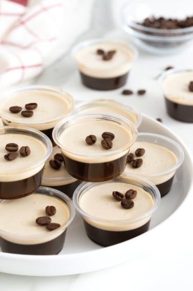 A white serving platter filled with espresso martini jello shots.