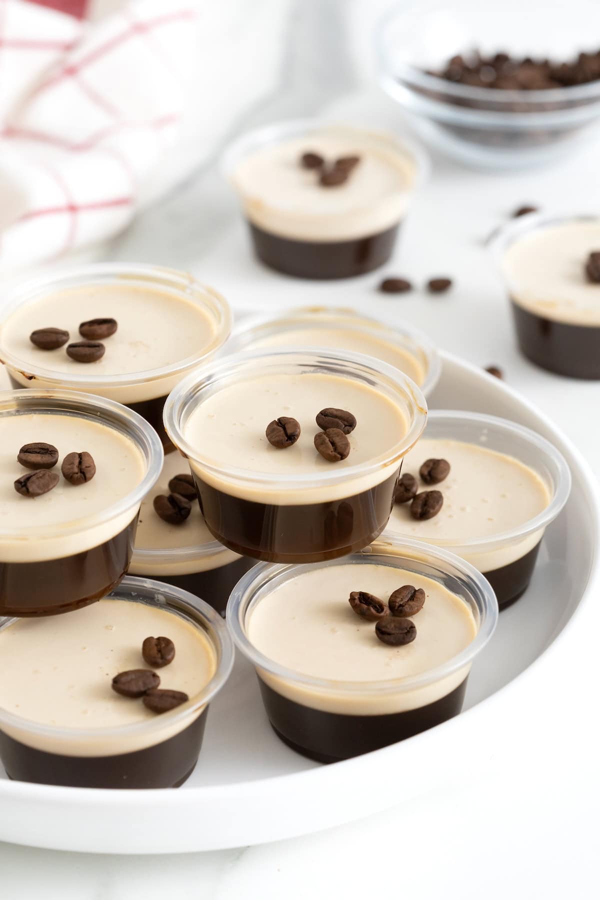 A white serving platter filled with espresso martini jello shots.
