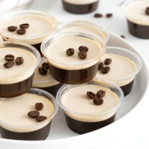 A white serving platter filled with espresso martini jello shots.
