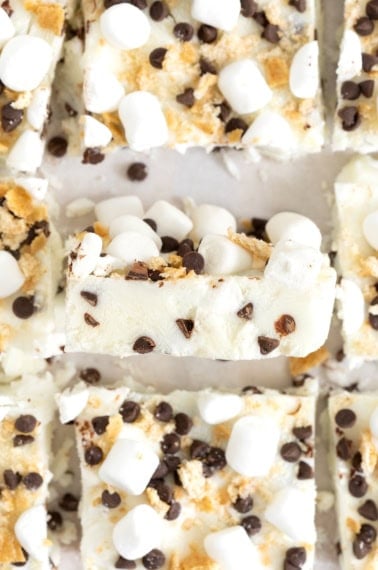 Frozen yogurt s'mores bars on a white surface.