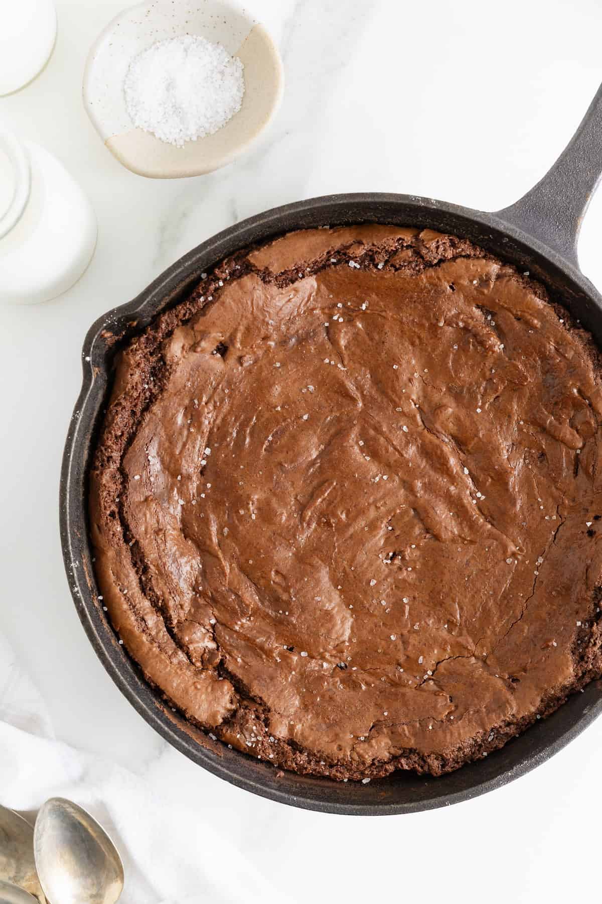 A brownie baked into a cast iron skillet.