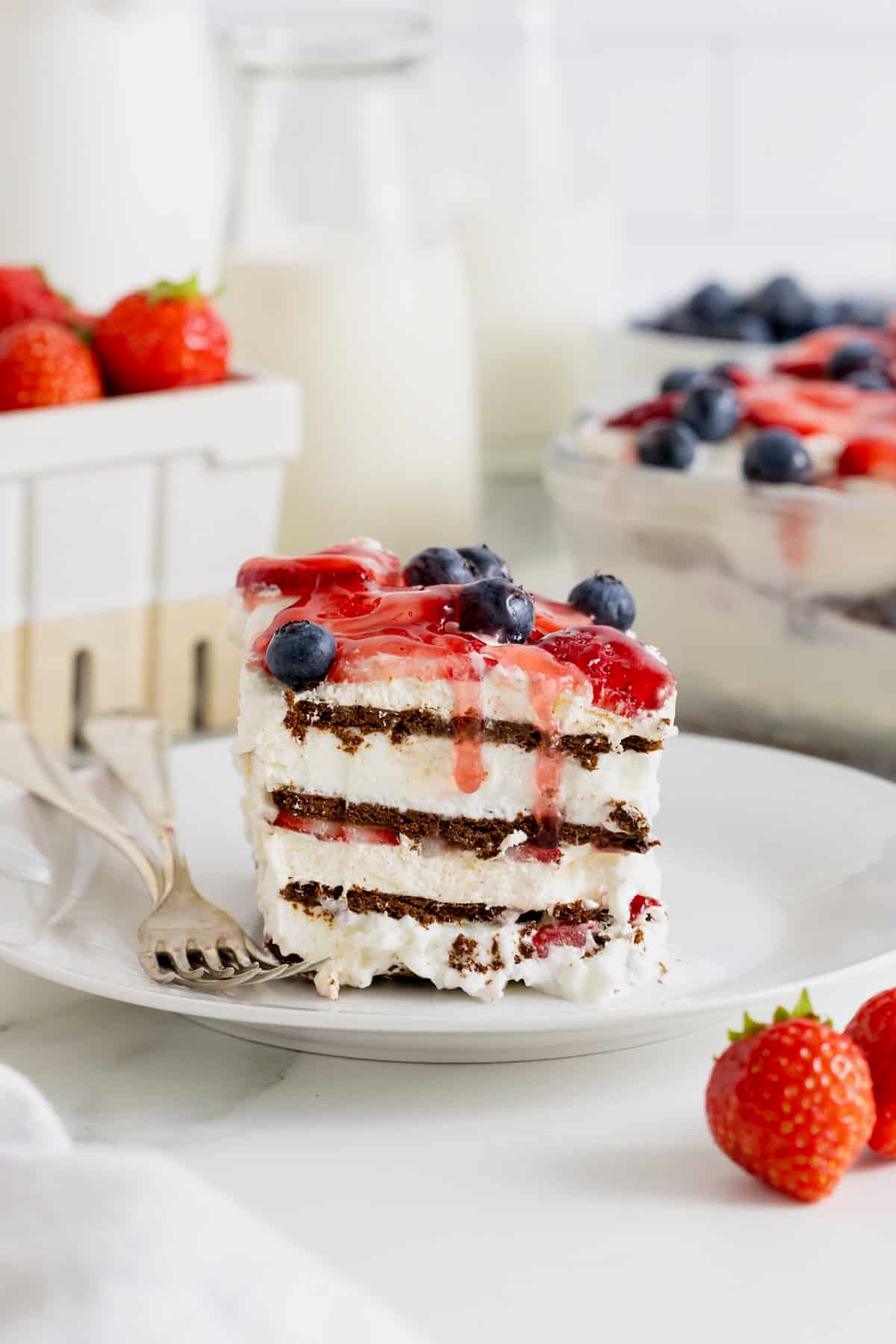 A slice of fresh berry ice cream sandwich cake on a white dessert plate.