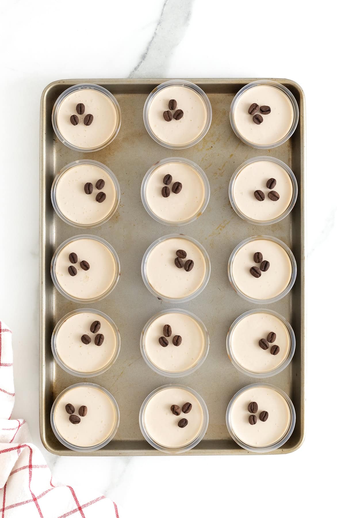 12 espresso martini jello shots on an aluminum baking sheet.