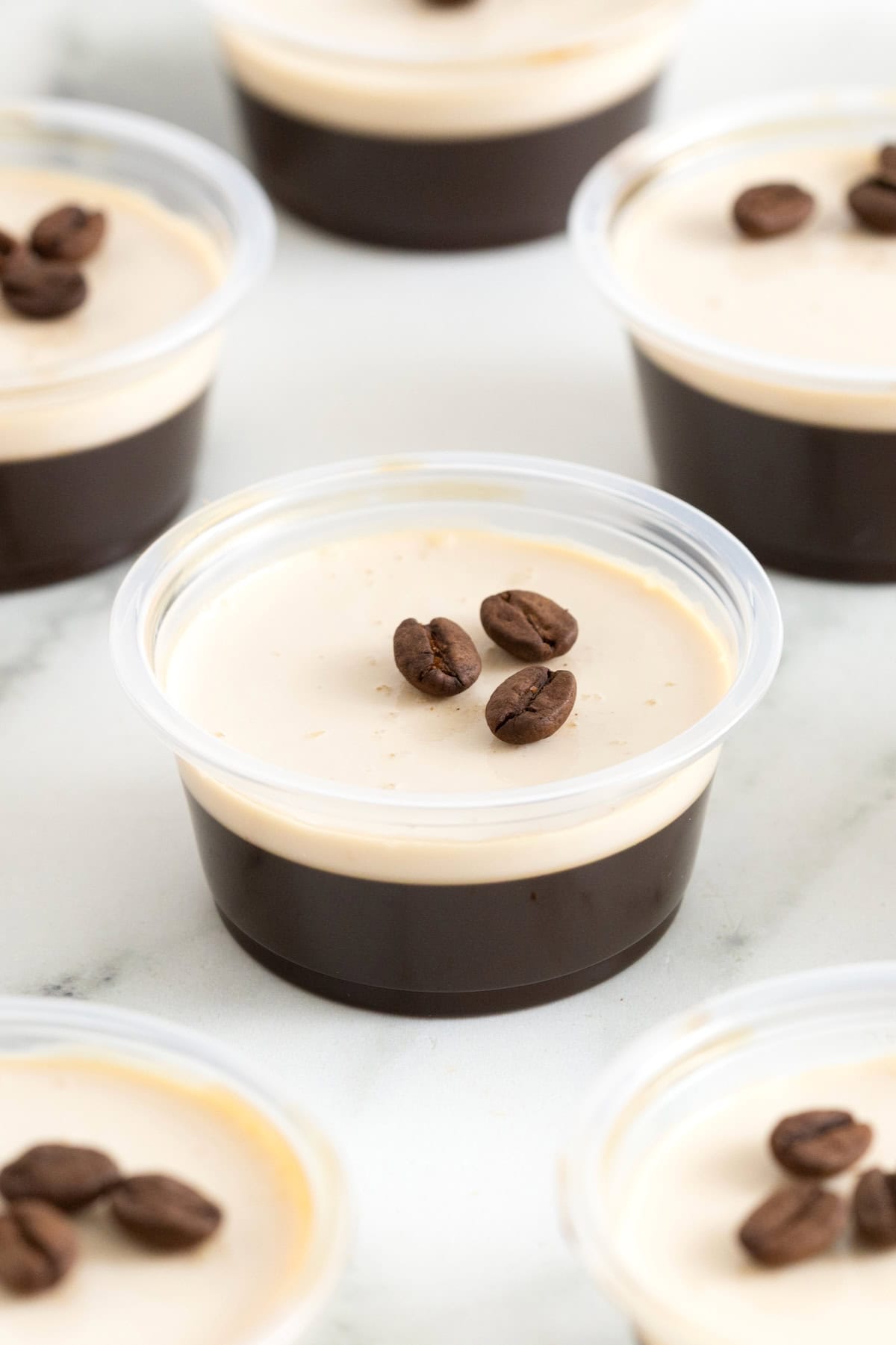 An espresso martini jello shot on a white marble counter.