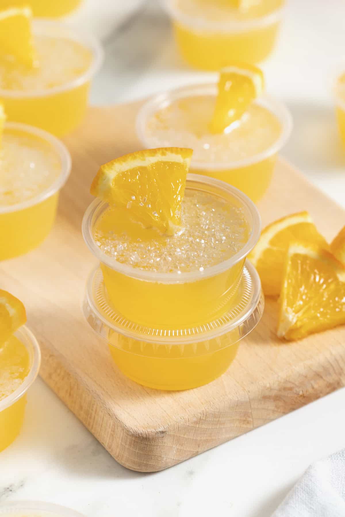 Mimosa Jello Shots on a wooden cutting board.