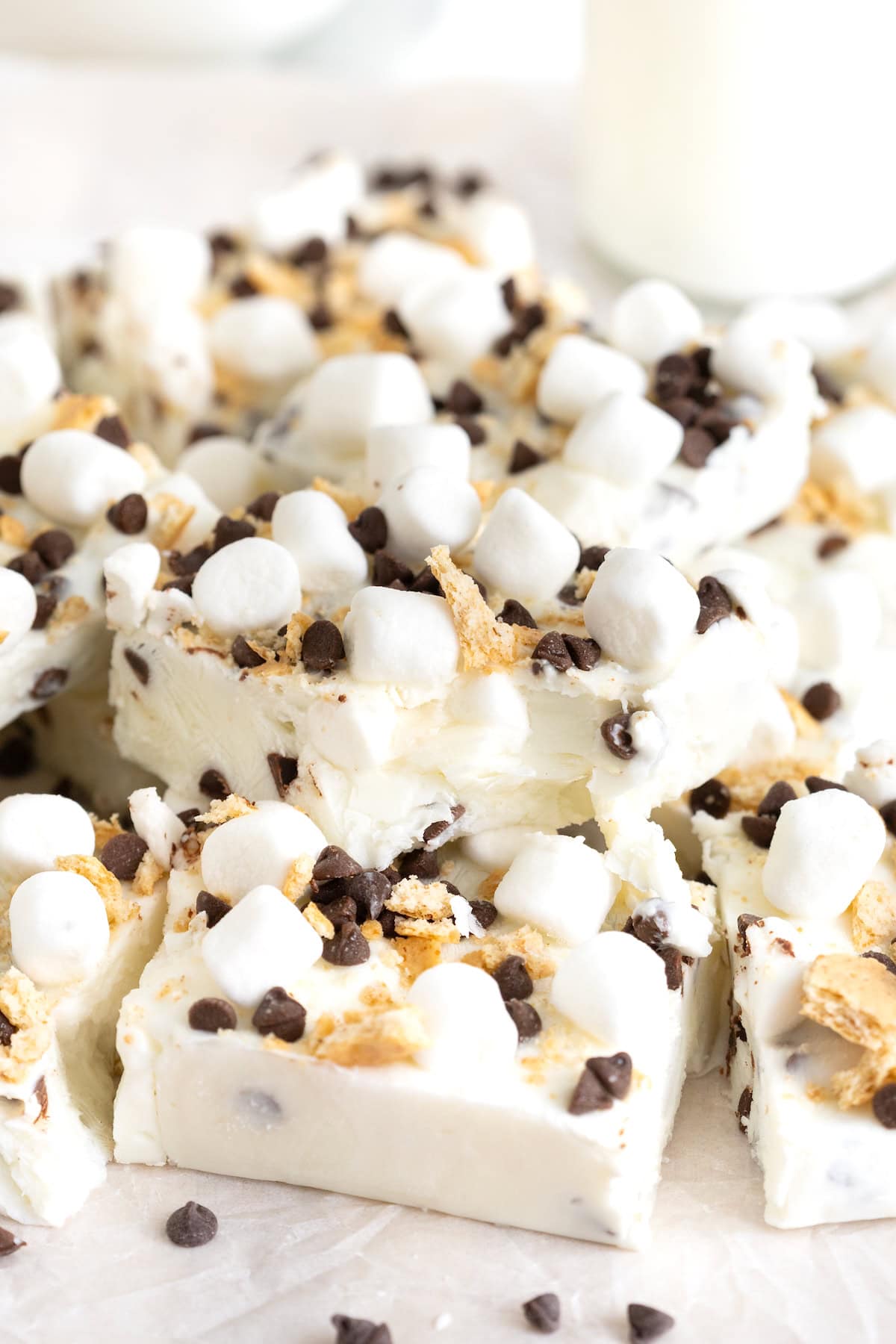 A pile of s'mores frozen yogurt bars. One bar has a bite out of it.