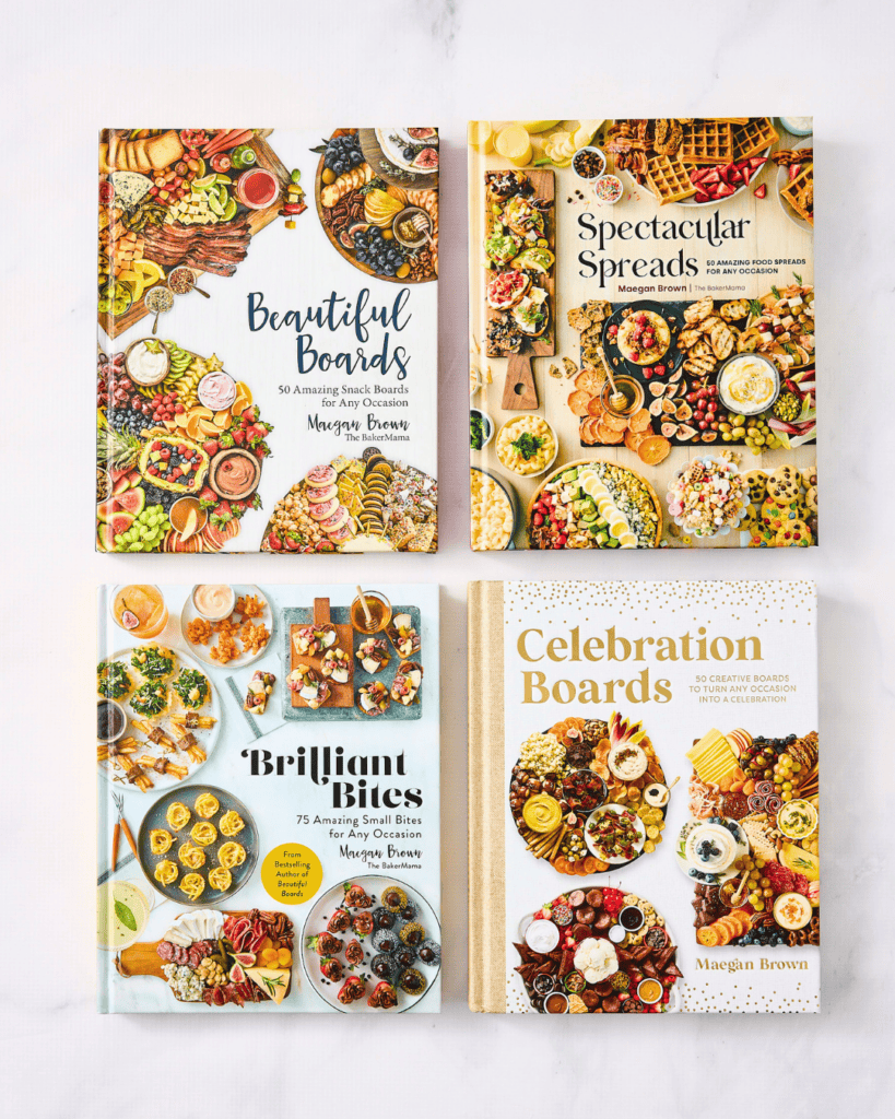 Beautiful Boards, Spectacular Spreads, Brilliant Bites and Celebration Boards cookbooks on a white marble counter.