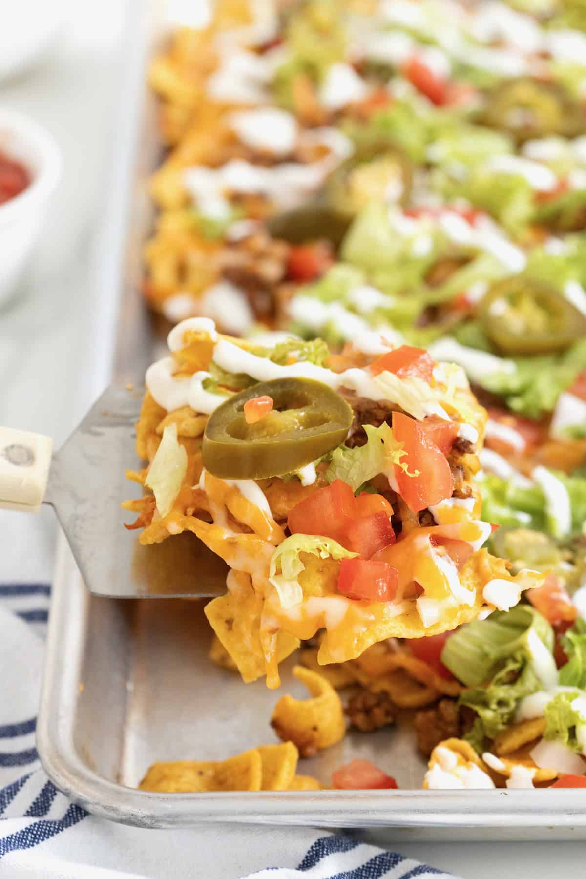 A spatula lifting a serving of sheet pan tacos out of the pan.