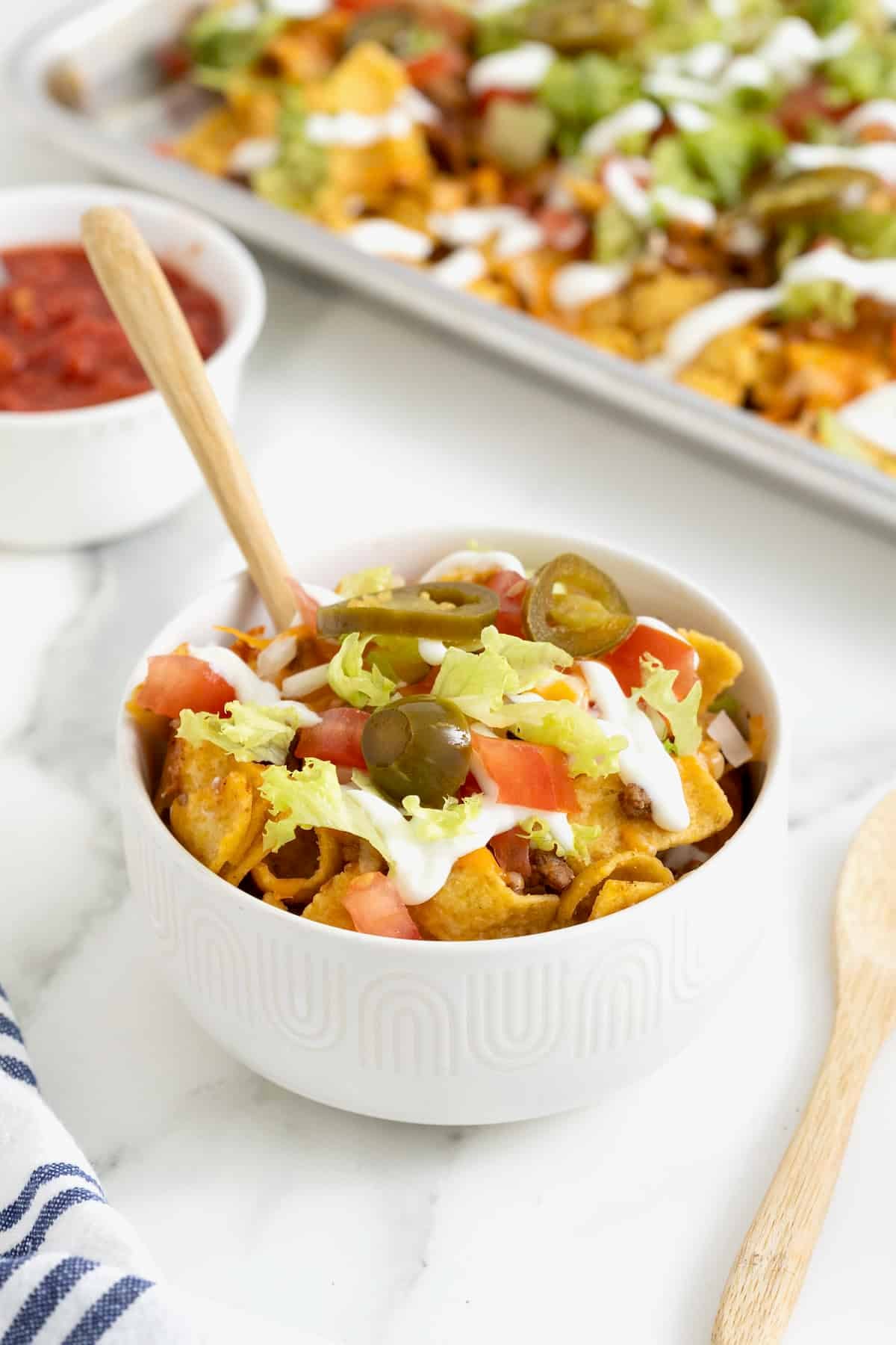A serving of walking tacos in a bowl with a fork sticking out.