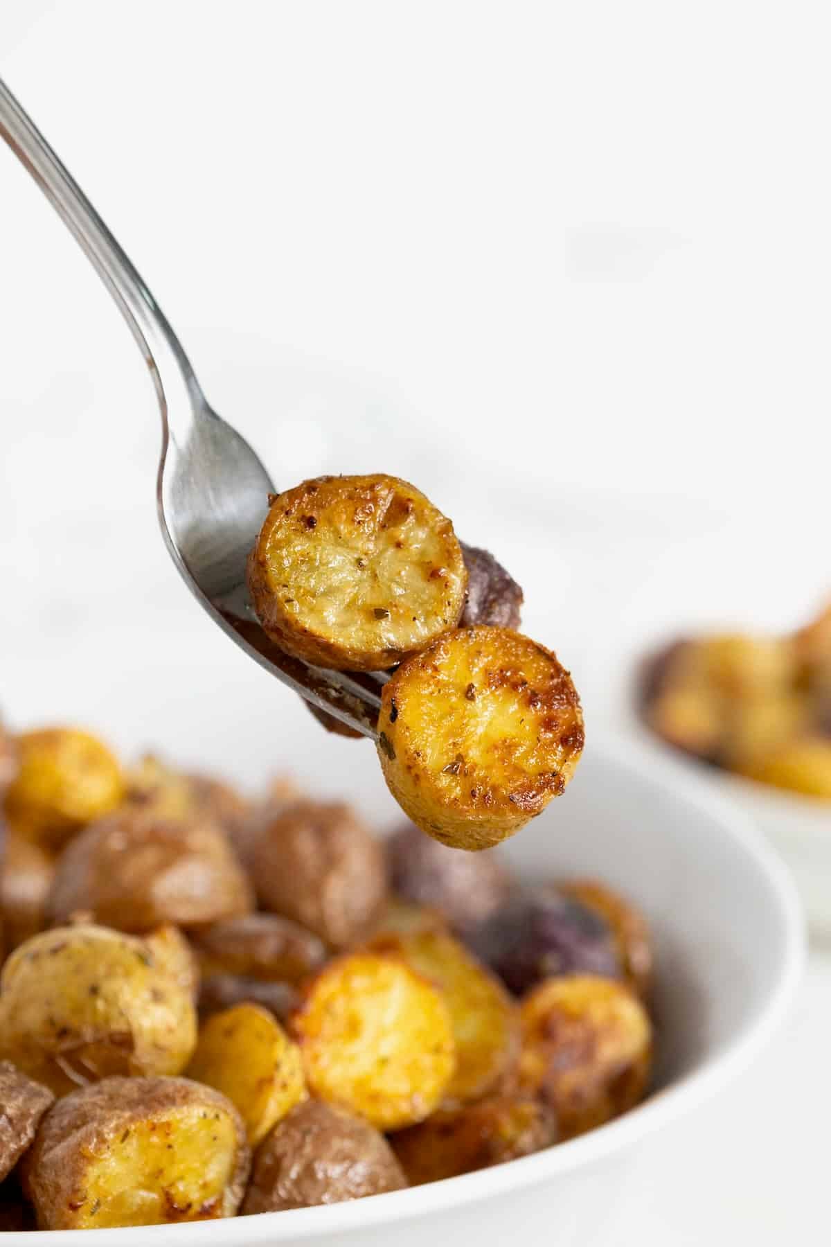 A bite of crispy ranch potatoes on a fork.
