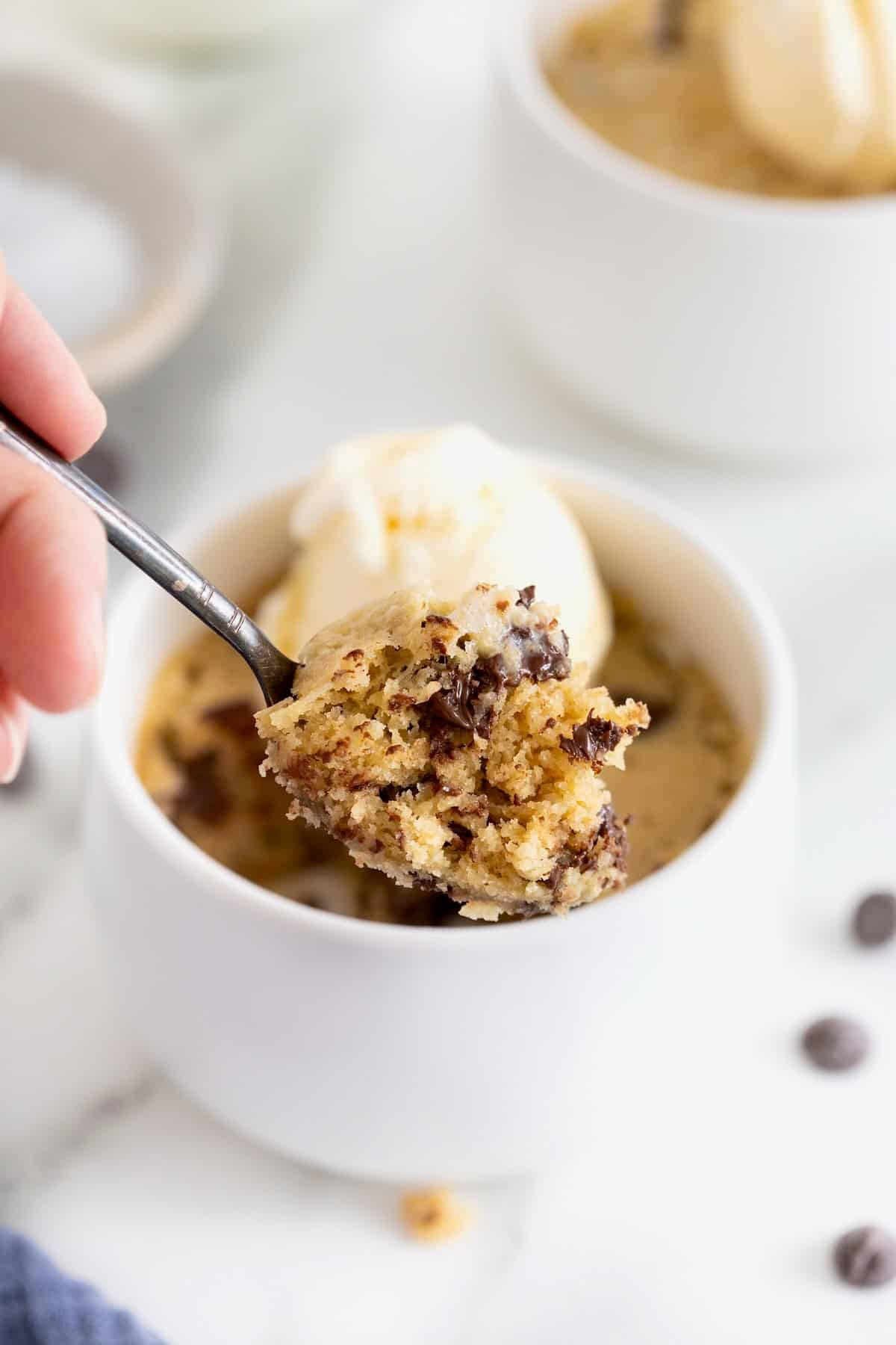 A bite of microwave chocolate chip cookie on a spoon.