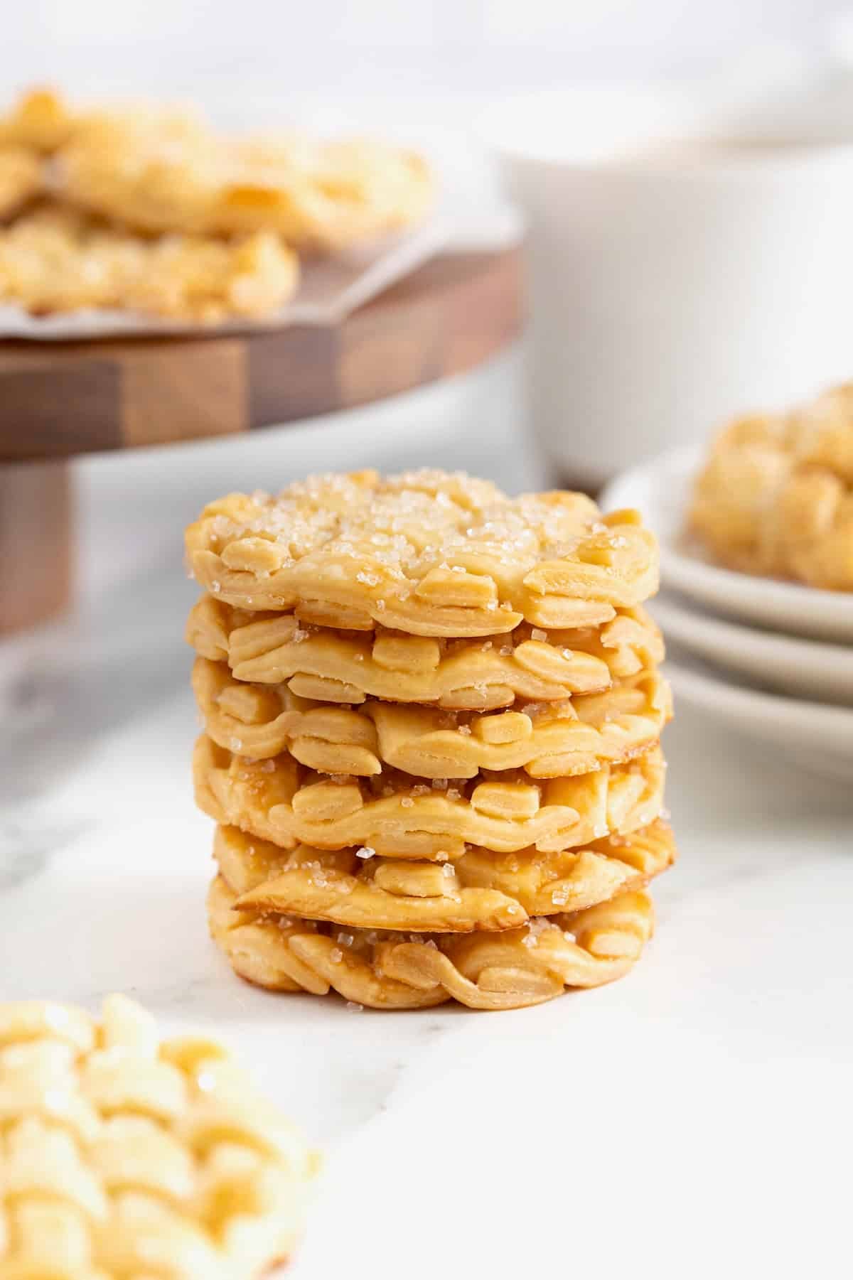 A stack of five lattice pie cookies on a white marble counter.
