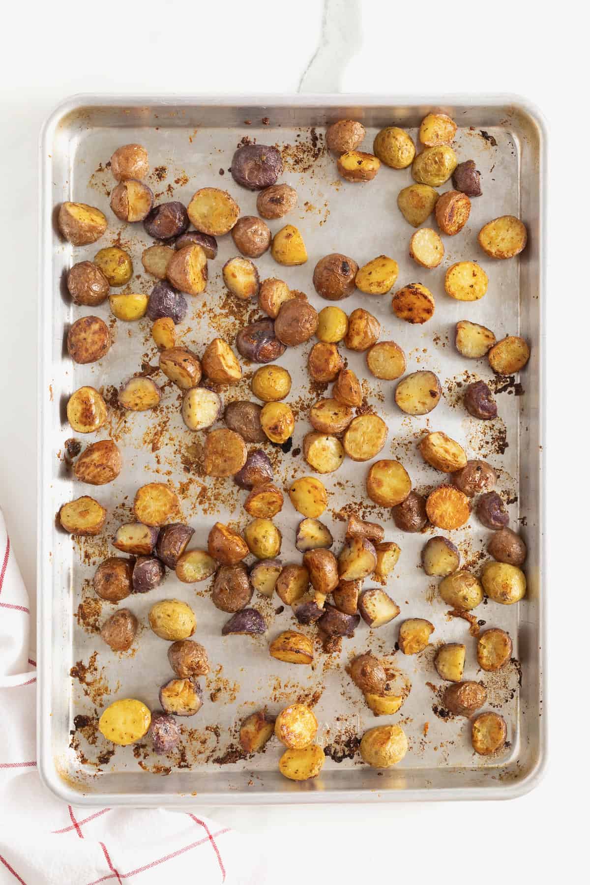 Crispy ranch potatoes on an aluminum baking sheet.